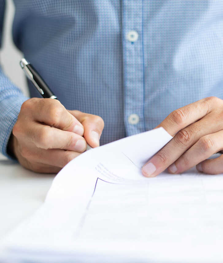 Homem escrevendo em folha de papel Homem escrevendo em folha de papel
